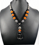 Collier ethnique artisanal avec pierres orange et noir agremente de breloques et d'armatures argentees