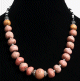 Collier ethnique artisanal imitation boules de corail rose agencees de perles argentees, noires et blanches