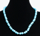 Collier ethnique artisanal imitation perles bleues claires agrementees d'autres petites perles en metal