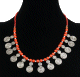 Collier ethnique artisanal imitation perles corail rouge agencees de perles argentees et de petites breloques tourbillon en metal