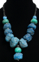 Collier ethnique artisanal imitation pierres difformes bleues et turquoises agrementees de perles argentees et de tubes noires