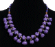 Collier ethnique artisanal imitation pierres mauves agencees de perles et agrementees de perles multicolores et de pieces en metal
